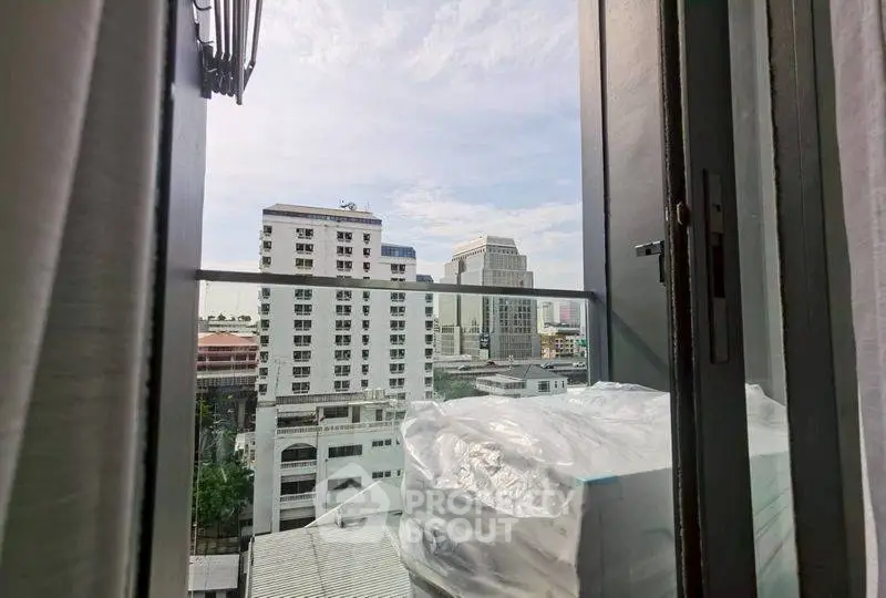 City view from a high-rise apartment balcony with modern buildings.
