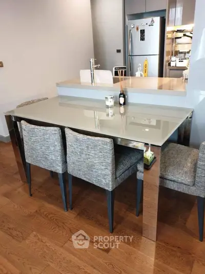 Modern dining area with sleek glass table and stylish chairs in a contemporary kitchen setting.