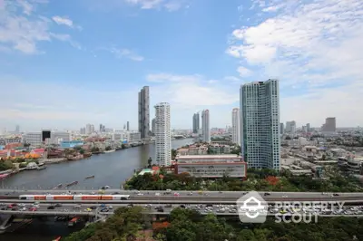 Stunning cityscape view with river and high-rise buildings under a clear blue sky.