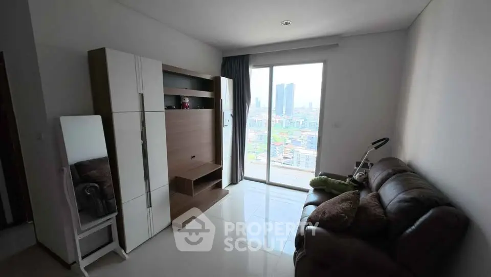 Modern living room with city view, featuring sleek furniture and large window for natural light.