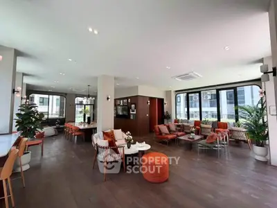 Spacious modern living room with stylish furniture and large windows offering natural light.