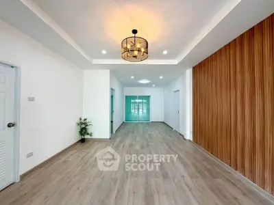 Spacious modern living room with elegant lighting and wooden accent wall