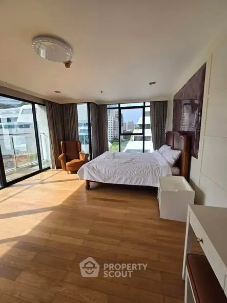 Spacious bedroom with large windows offering city views and abundant natural light.