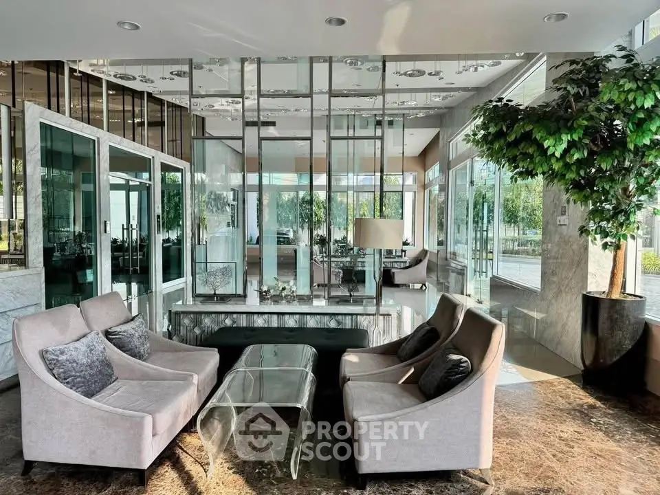 Luxurious modern lobby with elegant seating and glass walls, offering a sophisticated ambiance and natural light.
