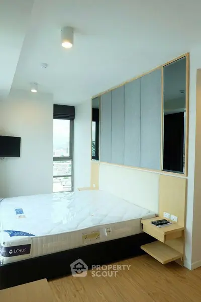 Modern bedroom with large window and stylish decor in urban apartment