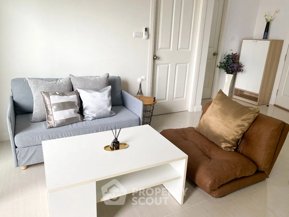 Cozy living room with modern sofa and floor seating, perfect for relaxation.