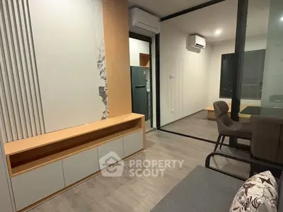 Modern living room with sleek design and air conditioning, featuring a view into a cozy adjacent room.