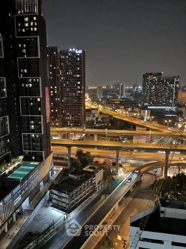 Stunning cityscape view from high-rise building at night with illuminated roads and skyline.