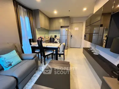 Modern living room with open kitchen, sleek furniture, and cozy dining area in a stylish apartment.