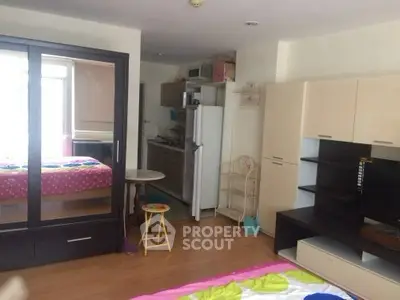 Cozy studio apartment with modern furniture and compact kitchen area.