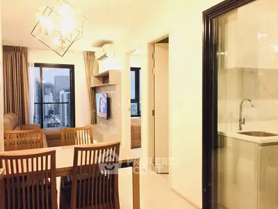 Modern apartment interior with dining area, living room, and city view from window.