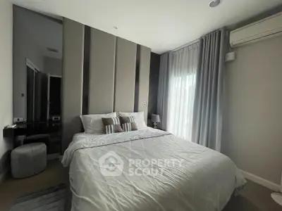 Modern bedroom with stylish decor and natural light, featuring a comfortable bed and elegant curtains.