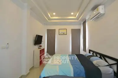 Modern bedroom with stylish ceiling lights and air conditioning, featuring a cozy bed and wall-mounted TV.