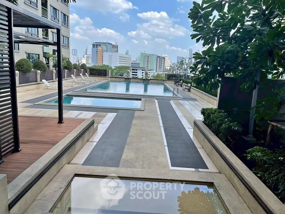 Luxurious rooftop pool with stunning city views and lush greenery, perfect for relaxation and leisure.