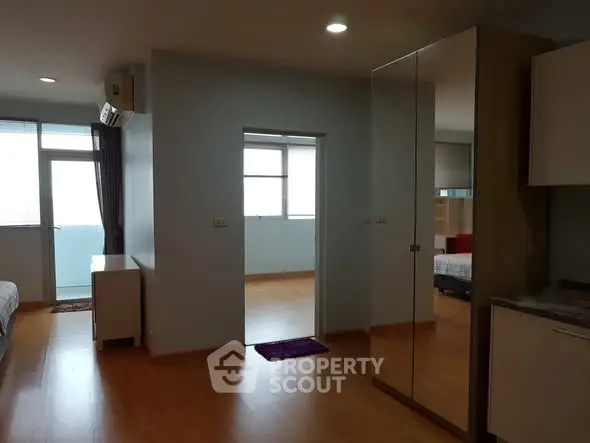 Spacious modern apartment interior with mirrored wardrobe and natural light