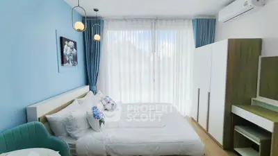 Bright and airy bedroom with modern decor and large window view.