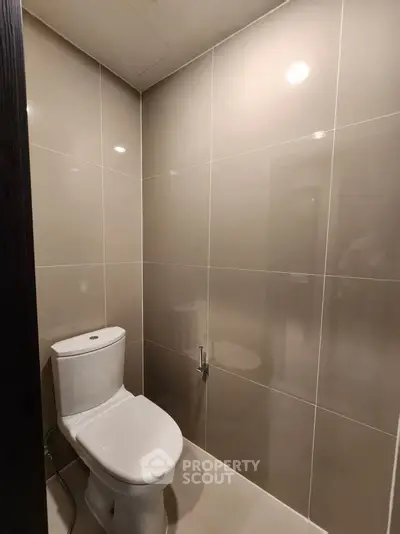 Modern bathroom with sleek tile walls and contemporary toilet design.
