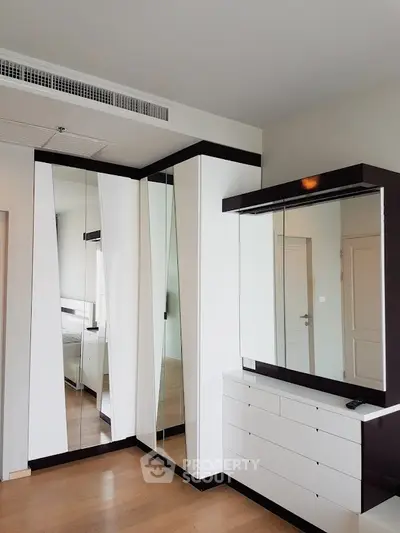 Modern bedroom with mirrored wardrobe and sleek white furniture