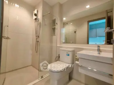 Modern bathroom with glass shower and sleek fixtures in a contemporary apartment.