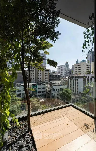 Stunning urban balcony with lush greenery and cityscape views, perfect for relaxation and enjoying the skyline.