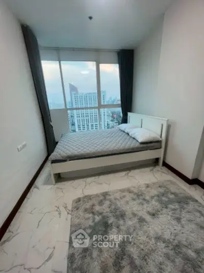 Modern bedroom with city view, featuring a cozy bed and stylish decor.