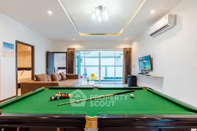 Spacious living room with pool table and modern decor, perfect for entertainment.