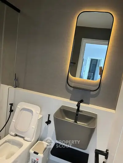 Modern bathroom with sleek fixtures and illuminated mirror