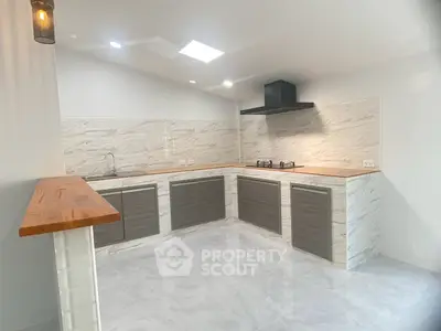 Modern kitchen with sleek cabinetry and gas stove in a bright, open layout.