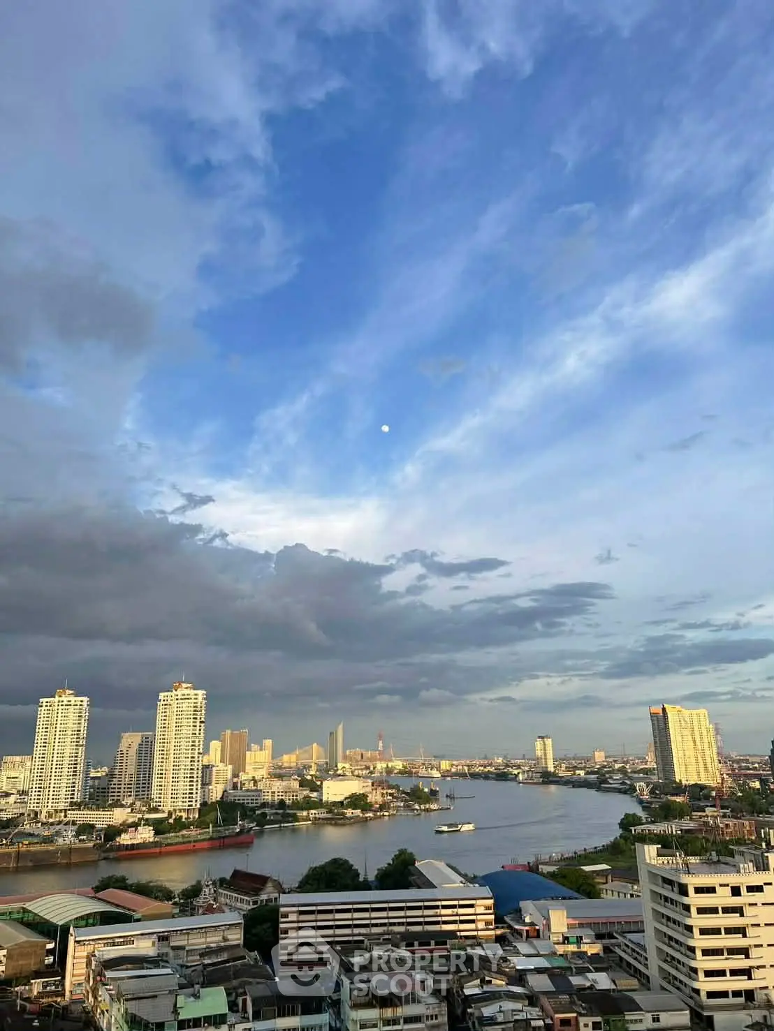 Stunning cityscape view with river and skyline under a vibrant blue sky.