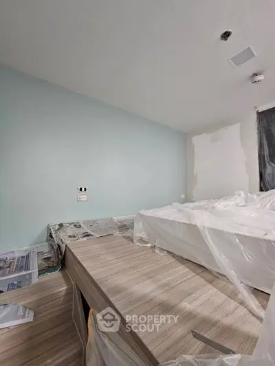 Modern bedroom under renovation with fresh paint and new flooring