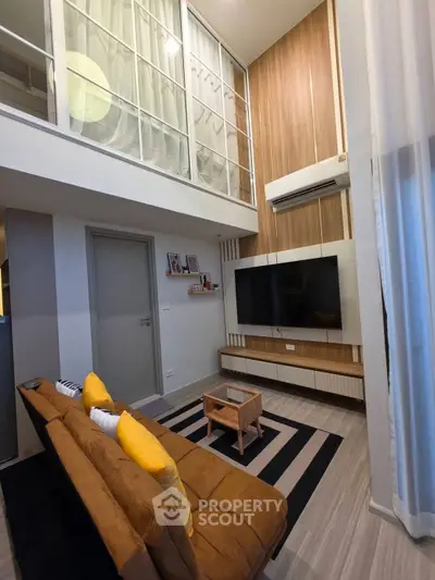 Modern loft-style living room with high ceilings and cozy decor