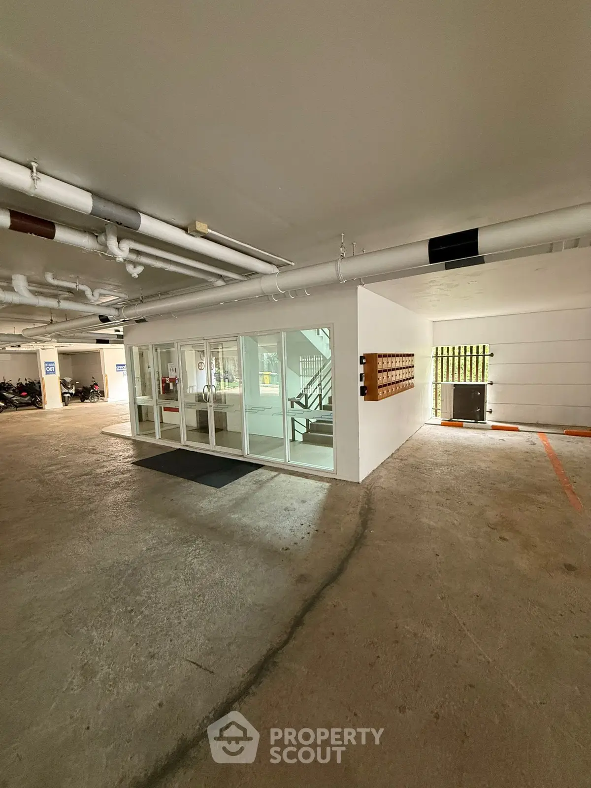 Spacious parking area with secure entrance and stair access in modern building.