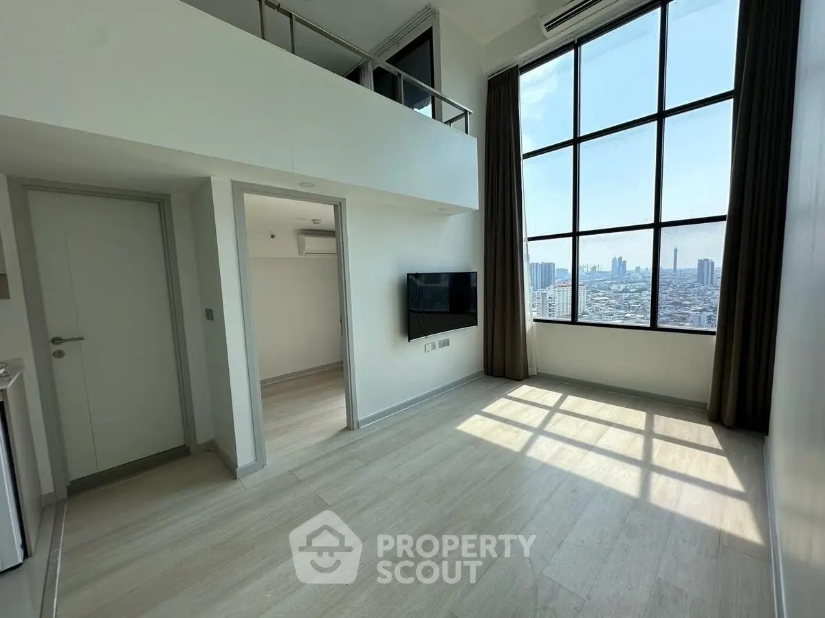 Modern loft apartment with high ceilings and large windows offering stunning city views.