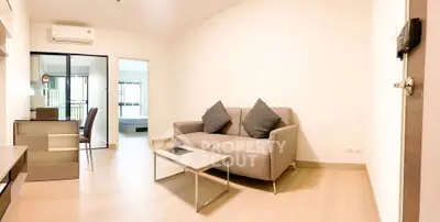 Modern living room with cozy sofa and open view to bedroom, perfect for urban living.