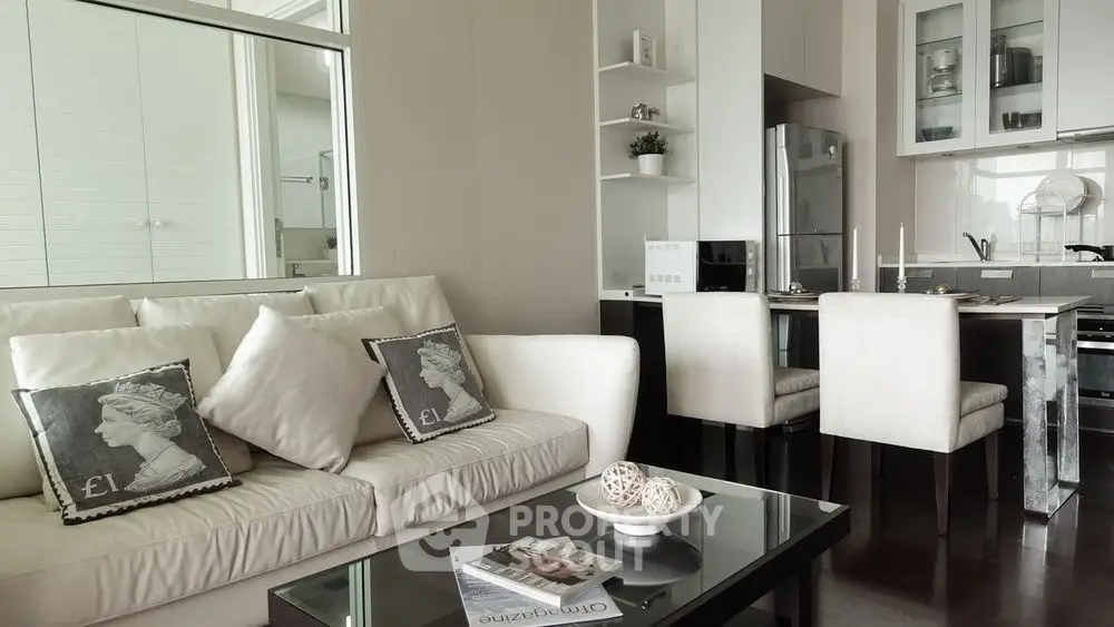 Modern open-plan living room and kitchen with elegant decor and neutral tones.