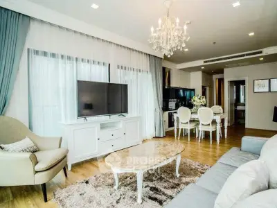 Elegant living room with chandelier, large TV, and stylish furniture in a modern apartment.
