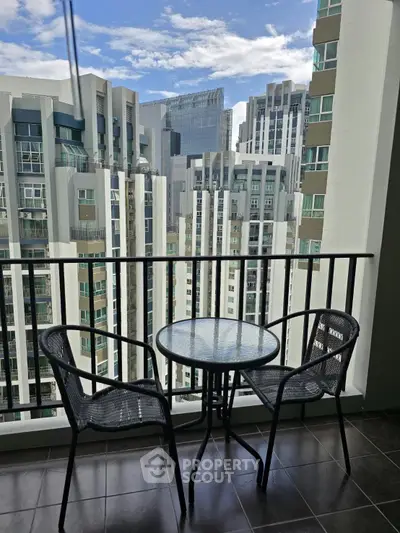Modern balcony with cityscape view, featuring sleek glass table and chairs, perfect for urban living.