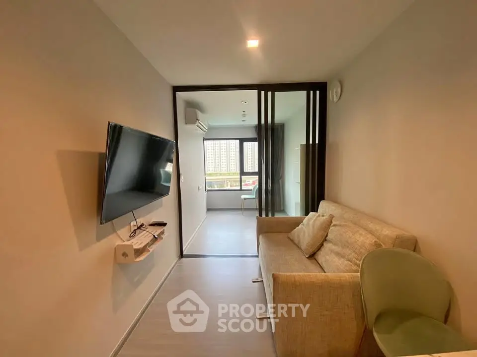 Modern living room with sleek design and wall-mounted TV in a cozy apartment.