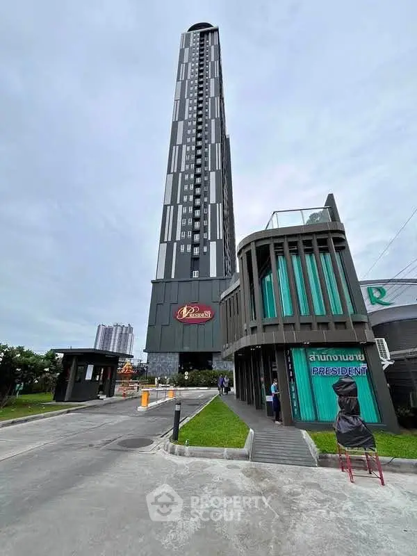 Modern high-rise building with sleek design and lush surroundings, ideal for urban living.