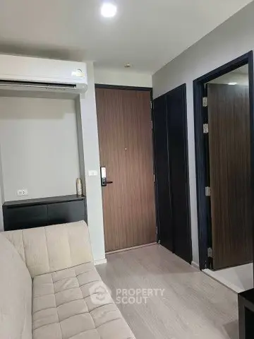 Modern apartment interior with sleek design and neutral tones, featuring a cozy sofa and stylish wooden doors.