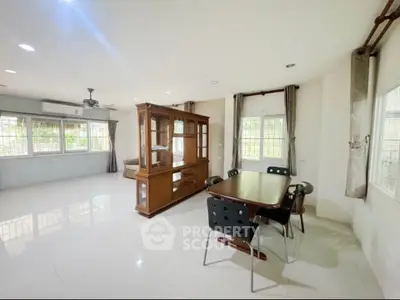 Spacious living room with dining area and large windows for natural light