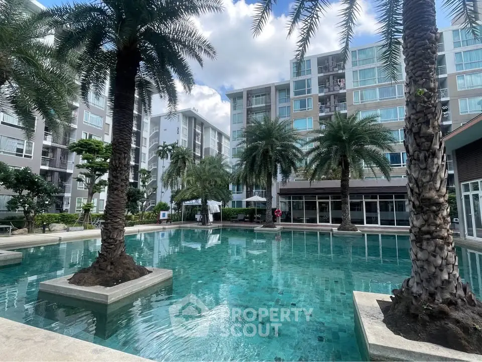 Luxurious condominium with stunning pool and lush palm trees, perfect for resort-style living.