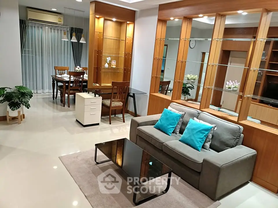 Spacious living room with modern decor and dining area, featuring elegant furniture and stylish lighting.