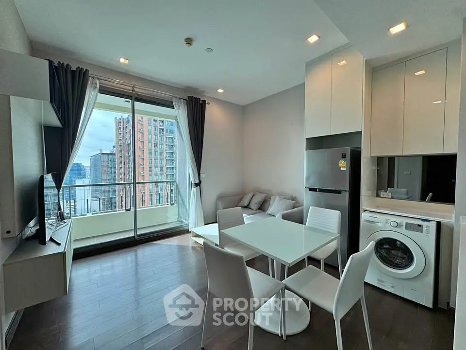 Modern living room with balcony view, dining area, and in-unit washer in a high-rise apartment.