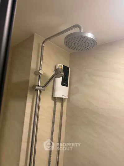 Modern bathroom shower with rain showerhead and water heater in elegant tiled setting.