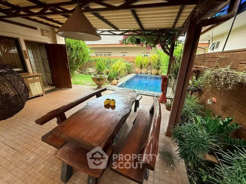 Charming outdoor patio with rustic wooden furniture and private pool, perfect for relaxation and entertaining.