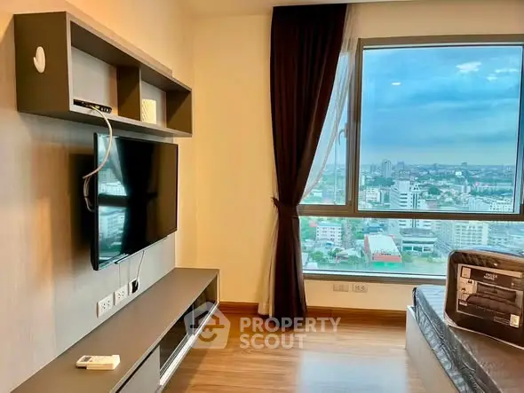 Modern living room with large window offering stunning city views, sleek TV setup, and elegant decor.
