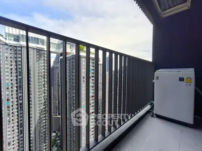 Modern high-rise balcony with cityscape view and compact washing machine.