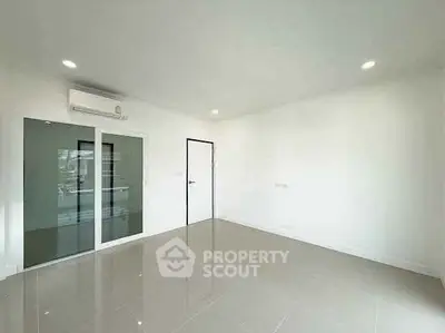Spacious empty room with glossy tiled floor and modern glass door