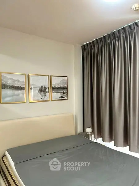 Cozy bedroom with elegant curtains and serene artwork, perfect for relaxation.